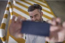 Homme prenant selfie avec smartphone à l'extérieur — Photo de stock