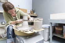 Женщина, работающая на гончарном круге в студии — стоковое фото