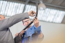Kfz-Mechaniker inspizieren Rohrleitungen in Werkstatt — Stockfoto