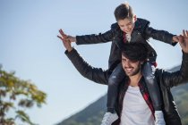 Pai carregando filho em ombros ao ar livre — Fotografia de Stock