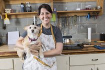 Portrait of jeweler and dog in workshop — Stock Photo