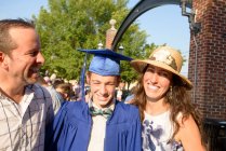 Adolescent et sa famille à la cérémonie de remise des diplômes — Photo de stock