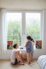 Mother sitting beside window, talking to son and daughter — Stock Photo