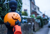 Ritratto di ragazzo in costume di Halloween, con zucca in mano e secchio per dolcetto o scherzetto — Foto stock