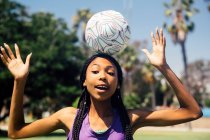 Підліток школярка футболіст балансує м'яч на голові на шкільному спортивному полі — стокове фото