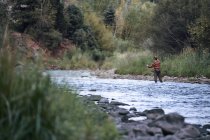 L'uomo in piedi nel fiume e la pesca — Foto stock