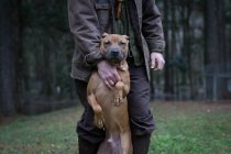 Homme et chien de compagnie debout sur les pattes arrière — Photo de stock