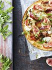 Fresh pizza with rocket leaves and figs, top view — Stock Photo