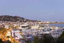 Paysage urbain avec hôtels en bord de mer et port de plaisance au crépuscule, Cannes, Côte d'Azur, France — Photo de stock