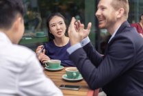 Grupo de empresários, tendo reunião no café, ao ar livre — Fotografia de Stock