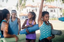 Écolières se préparant pour la pratique du yoga sur le terrain de sport scolaire — Photo de stock