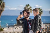 Padre e figlio prendere selfie all'aperto — Foto stock