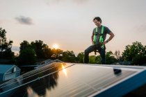 Arbeiter steht auf Hausdach und installiert Solarzellen — Stockfoto