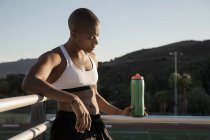 Retrato de mujer con ropa deportiva sosteniendo botella de agua - foto de stock