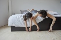 Madre e figlia sdraiati sul letto in camera da letto luce — Foto stock