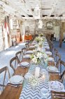 Place settings with table decorations in barn — Stock Photo