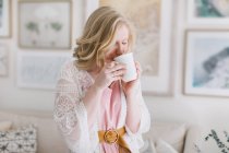 Giovane donna in soggiorno bere caffè — Foto stock