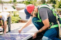 Trabalhadores que instalam painéis solares no telhado da casa — Fotografia de Stock