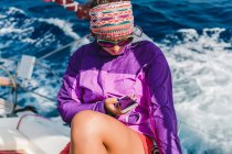 Junge Frau schaut auf Smartphone an Bord von Jacht, Kroatien — Stockfoto