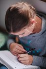 Mädchen am Boden konzentriert sich auf Hausaufgaben schreiben — Stockfoto