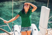Woman on sailboat looking up at something — Stock Photo