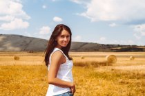 Портрет жінка в пшеничному полі, дивлячись на камеру — стокове фото