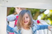 Kleinkind im Kindergarten, Porträt auf Klettergerüst im Garten — Stockfoto