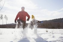 Homem e filho marchando na paisagem coberta de neve — Fotografia de Stock