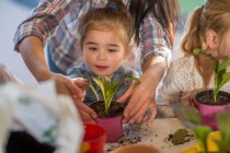 Metà donna adulta aiutare i bambini piccoli con attività di giardinaggio — Foto stock