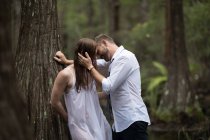 Пара спирається на дерево і цілується — стокове фото