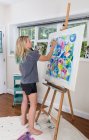 Female artist painting abstract canvas  in studio — Stock Photo