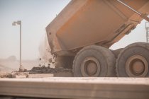 Dump truck in quarry, tipping load of stones — Stock Photo