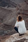 Giovane donna accovacciata sulle rocce, guardando la vista, Cappello Messicano, Utah, Stati Uniti d'America — Foto stock