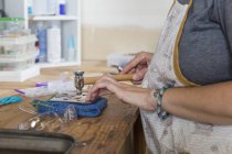 Close up of female jeweler working in workshop — Stock Photo
