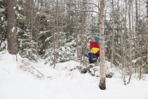 Homem e filho olhando para cima da floresta de inverno — Fotografia de Stock
