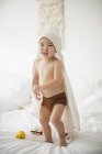 Little boy with hooded towel in bed — Stock Photo