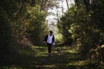 Jeune fille marchant avec chien en milieu rural — Photo de stock