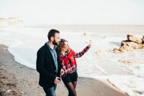 Romantic mid adult couple pointing from beach, Odessa Oblast, Ukraine — Stock Photo
