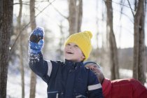 Man and son looking up in winter forest — Stock Photo