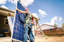 Ouvriers se préparant à installer des panneaux solaires, vue à faible angle — Photo de stock