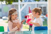 Junges Mädchen im Freien mit Freunden, Smartphone in der Hand, Kopfhörer teilen — Stockfoto