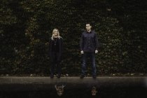 Ritratto di coppia adulta in piedi davanti al fogliame — Foto stock