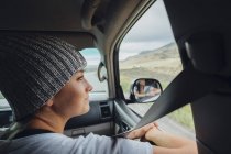 Jeune femme assise dans une voiture et regardant la fenêtre de la voiture, Silverthorne, Colorado, USA — Photo de stock