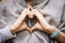 Mani donna rendendo forma di cuore — Foto stock