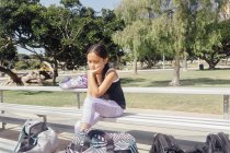 Studentessa seduta sulla panchina del campo sportivo scolastico — Foto stock
