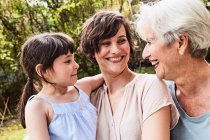 Portrait of senior woman with grown daughter and granddaughter, outdoors, smiling — Stock Photo