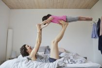 Madre e figlia giocare sul letto in camera da letto luce — Foto stock
