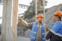 Two quarry workers in quarry, having discussion — Stock Photo