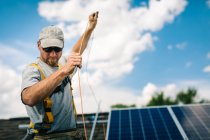 Workman l'installazione di pannelli solari sul tetto della casa — Foto stock