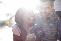 Man and woman with digital camera outdoors — Stock Photo